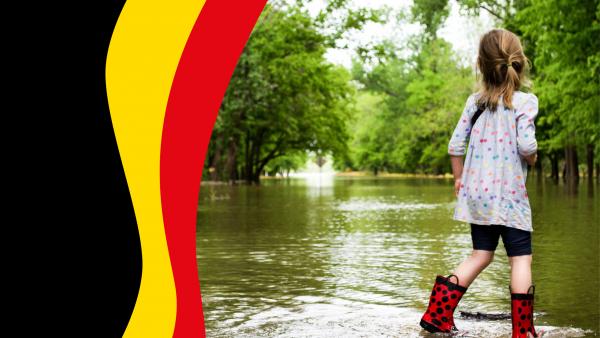 Drapeau belge avec petite fille avec botte dans les inondations